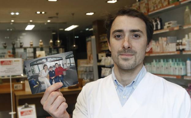 El farmacéutico Alejandro Sacristán sujeta una foto antigua de su madre, Carmen Eijo, en la aparecen él y su hermano mayor, Fernando. juan carlos tuero