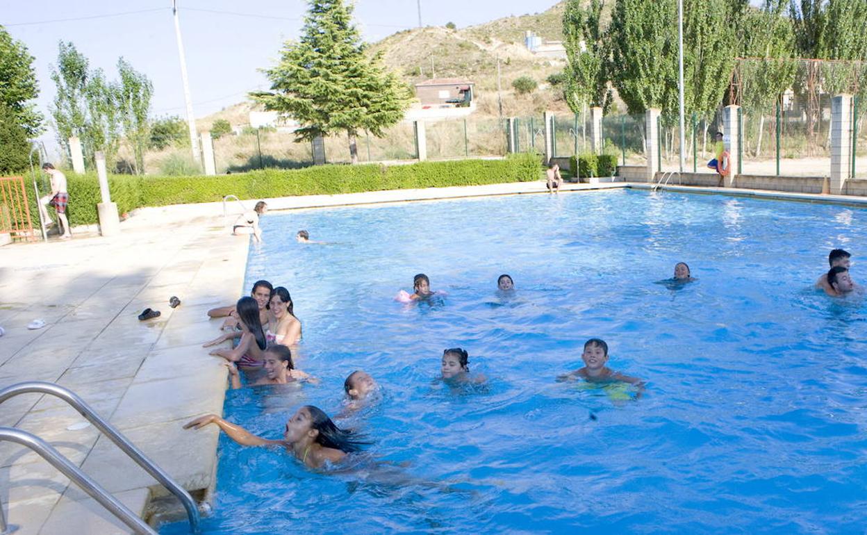 Unos niños se bañan en una piscina. 