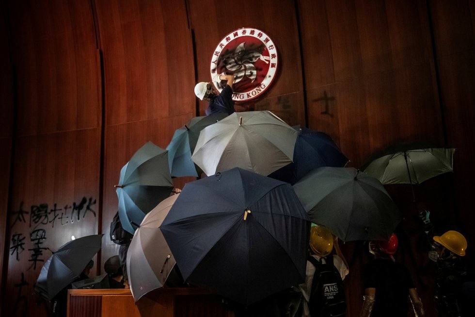 Un hombre hace un grafiti sobre el emblema regional de Hong Kong después de que un grupo de manifestantes asaltaran el Parlamento, el 1 de julio de 2019. Autor: TYRONE SIU (REUTERS)
