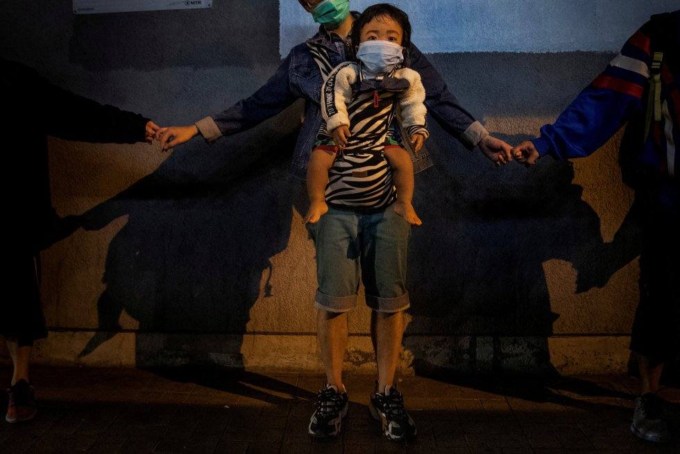 Una madre con su bebé participa en una cadena humana en señal de solidaridad en Kowloon Bay en Hong Kong, el 30 de noviembre de 2019. Autor: LEAH MILLIS (REUTERS)
