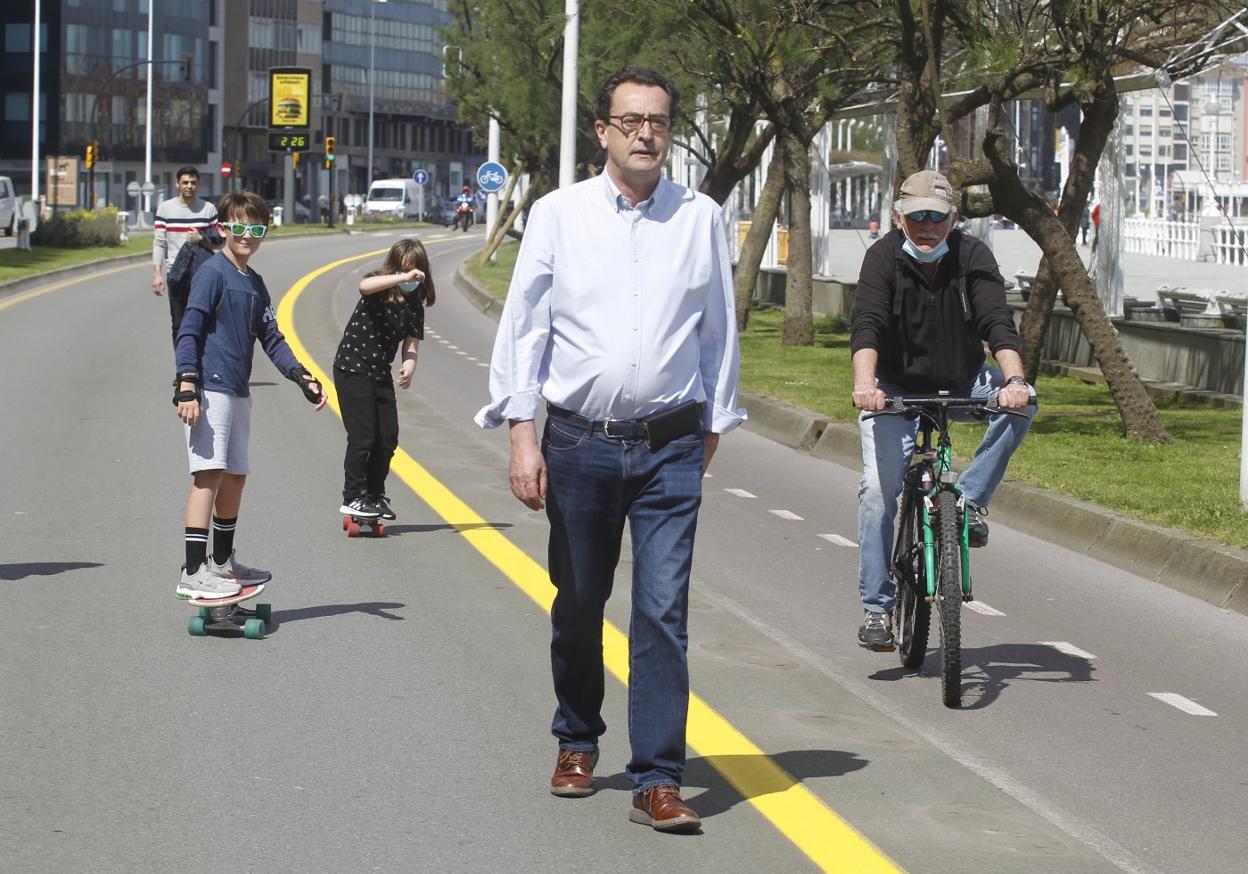 Cosme García camina por el carril del Muro cerrado al tráfico la semana pasada, junto a un ciclista por el carril bici recién ensanchado. 