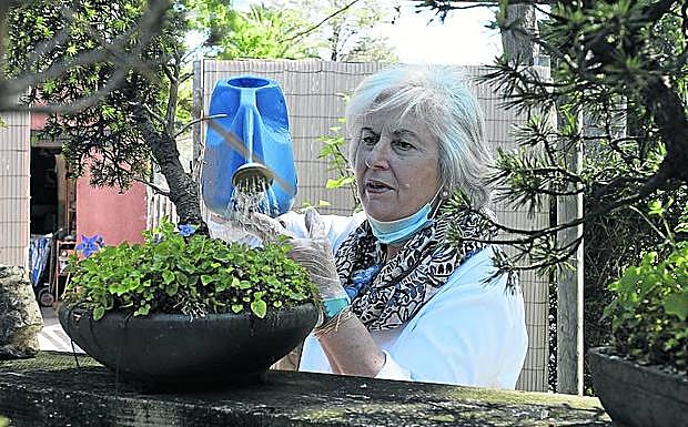 Alina Brown realiza labores de mantenimiento del jardín del gijonés Museo Evaristo Valle