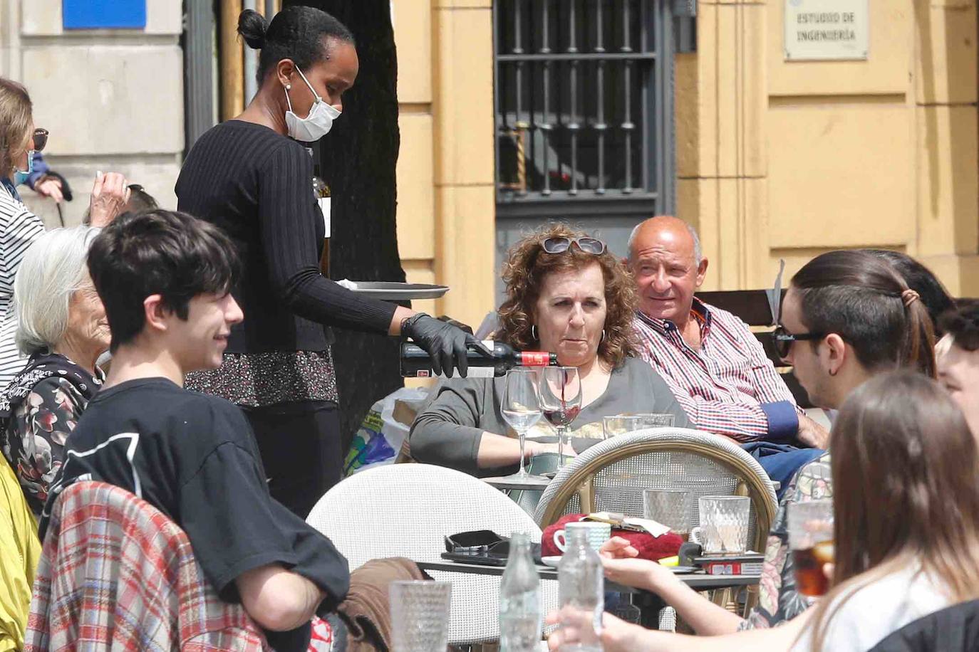 Tras ocho semanas con las verjas bajadas y las sillas y mesas apiladas, los establecimientos hosteleros de Gijón han vuelto a colocar sus terrazas. Eso sí, bajo estrictas medidas de higiene y aforo para prevenir el contagio de coronavirus. 