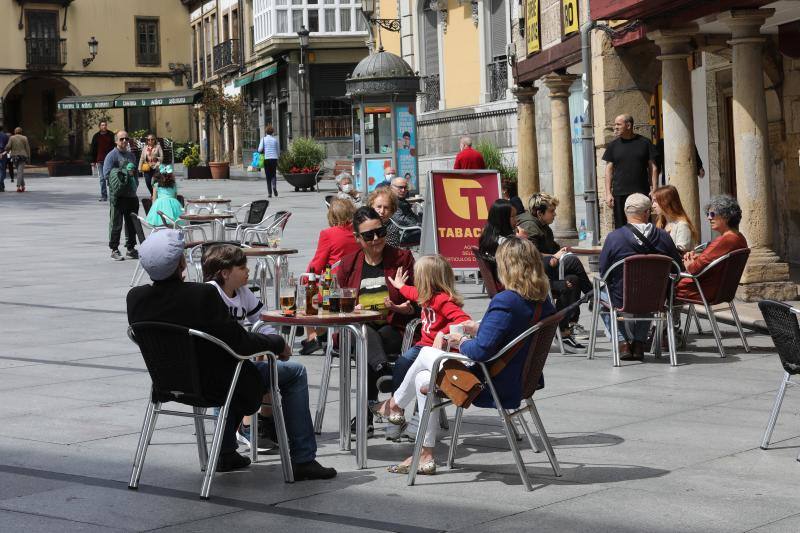 Por primera vez desde que se declaró el estado de alarma por la pandemia de coronavirus los asturianos han podido acudir a las terrazas de bares y cafeterías. Este lunes ha comenzado la fase 1 de la desescalada en el Principado y una de las medidas de alivio del confinamiento es la apertura de terrazas, aunque los establecimientos hosteleros deben acatar estrictas medidas de precaución, como la limpieza exhaustiva de las sillas y mesas o la limitación de aforo. 