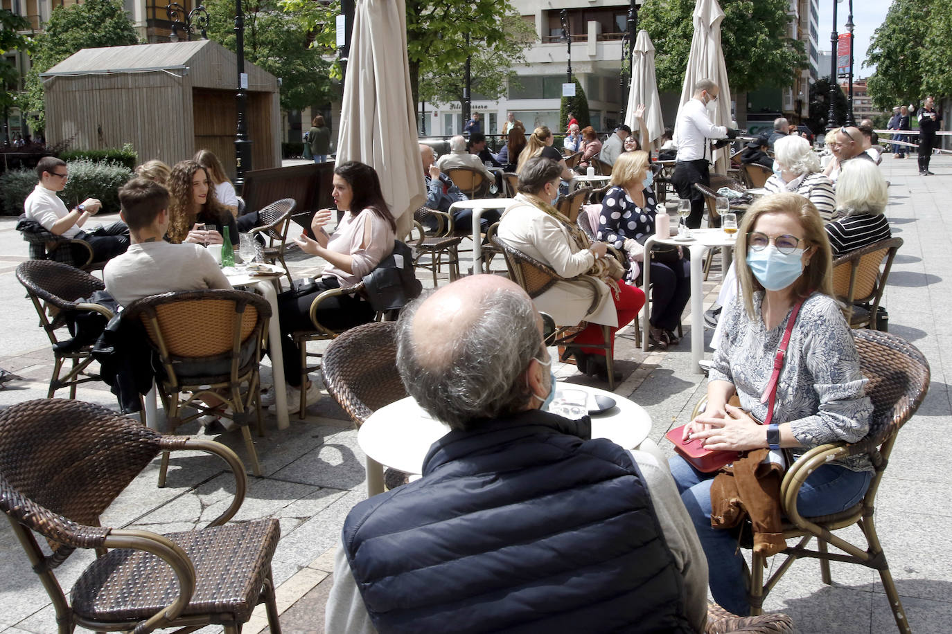 Por primera vez desde que se declaró el estado de alarma por la pandemia de coronavirus los asturianos han podido acudir a las terrazas de bares y cafeterías. Este lunes ha comenzado la fase 1 de la desescalada en el Principado y una de las medidas de alivio del confinamiento es la apertura de terrazas, aunque los establecimientos hosteleros deben acatar estrictas medidas de precaución, como la limpieza exhaustiva de las sillas y mesas o la limitación de aforo. 