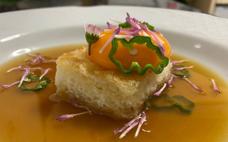 Sopa de miel de Sariegu con naranja y limón, yema de pita semicurada, pimientos de Padrón y tosta de pan blanco con flores