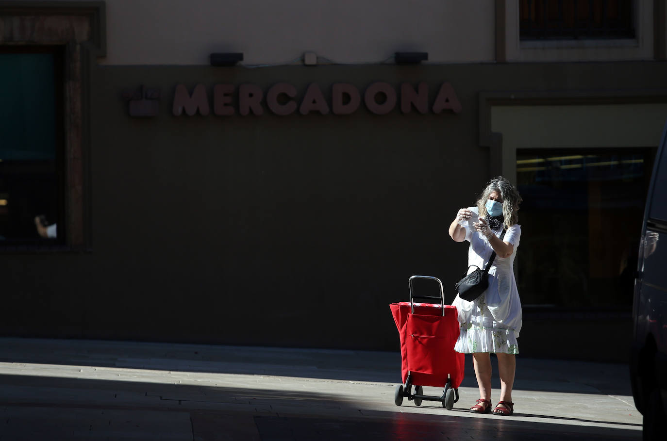 30 de abril. Oviedo | Una mujer hace la compra con una mascarilla. 