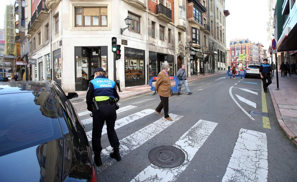 Un agente de la Policía Local informa a un conductor del cierre al tráfico de la calle Mendizábal. 
