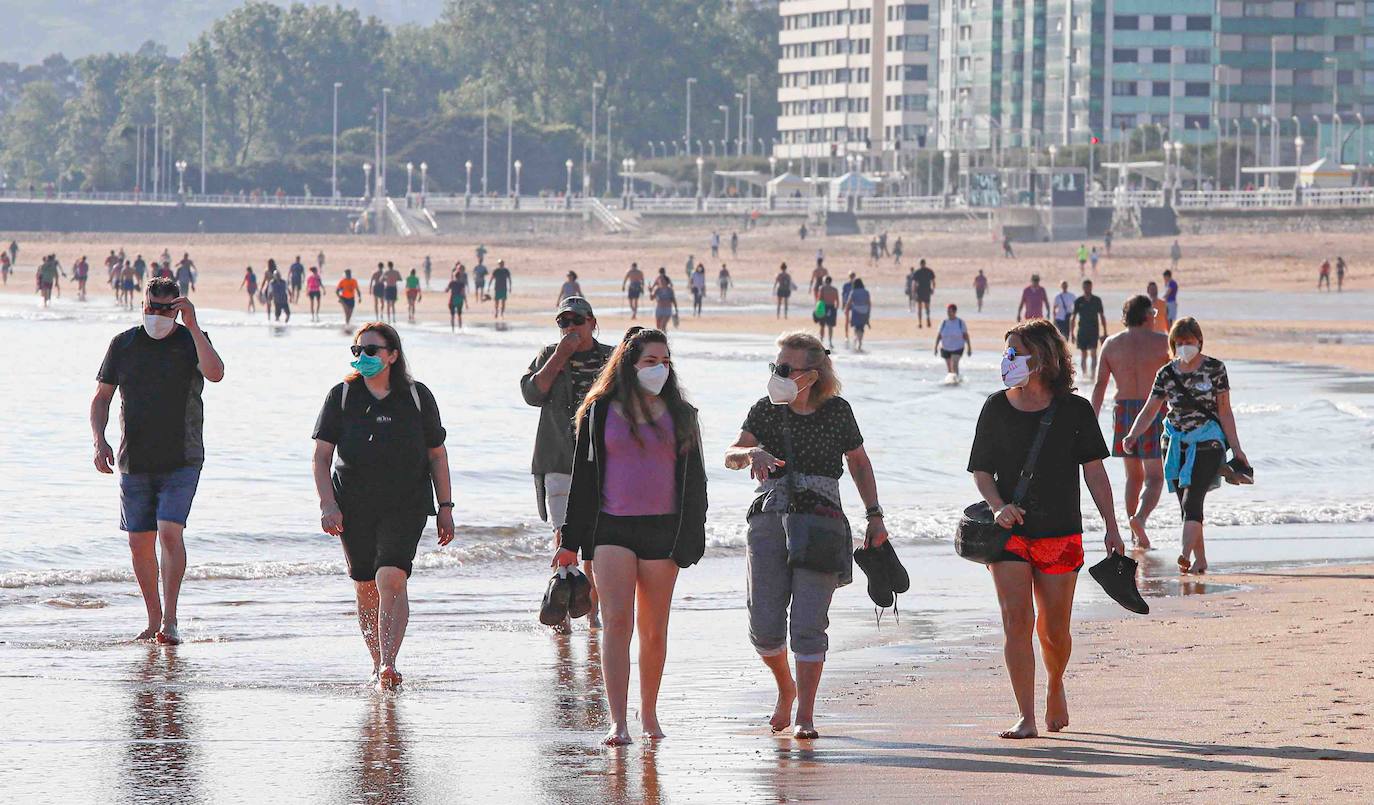 El sol y el buen tiempo han animado a los asturianos a ir a las playas y terrazas, eso sí, ataviados con sus mascarillas —obligatorias desde el jueves en espacios públicos cerrados y lugares abiertos siempre que no se pueda garantizar el distanciamiento de dos metros—. Además, este viernes se ha confirmado que todo el Principado comenzará el lunes la fase 2 de la desescalada del confinamiento por el coronavirus y alguna de las medidas que se adoptará será la reapertura de centros comerciales. 