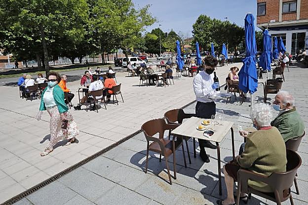 Una terraza con las mesas muy separadas y repletas de clientes, ayer, junto a las piscinas de El llano. 