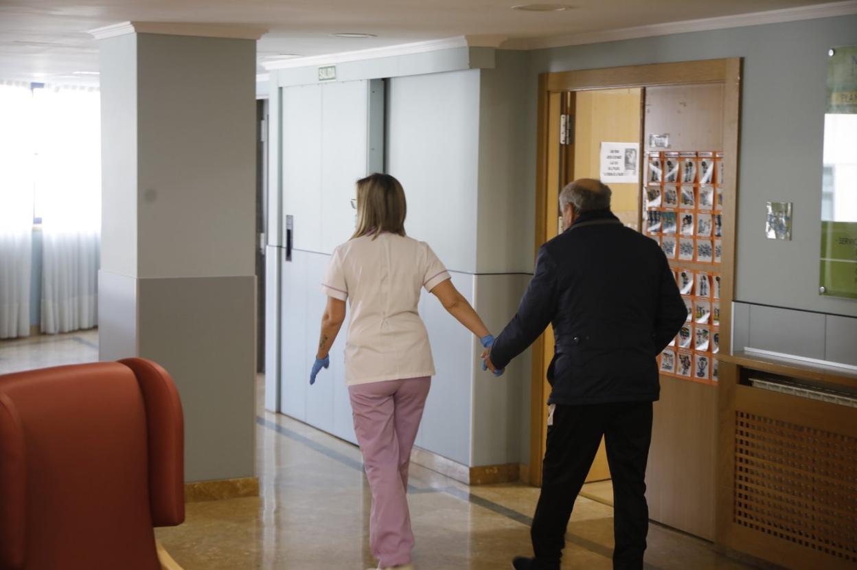 Una trabajadora acompaña a un residente en uno de los centros del ERA. 