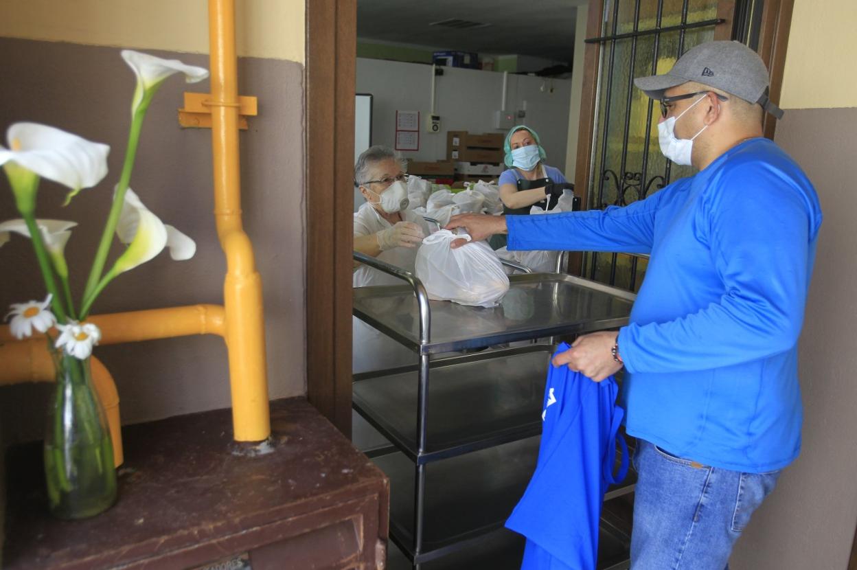 Sor Esperanza entrega una bolsa con comida a un hombre. 