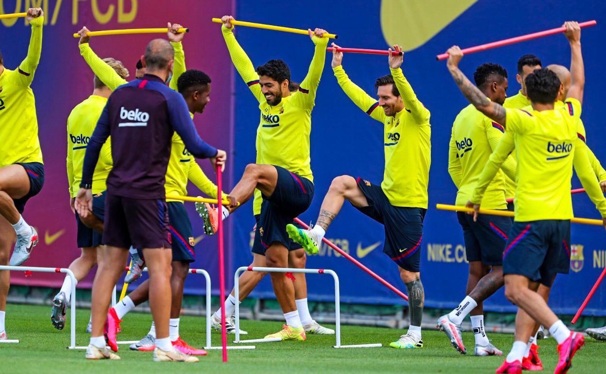 Leo Messi, en el centro junto a Luis Suárez, sonriente en el entrenamiento del Barça. 