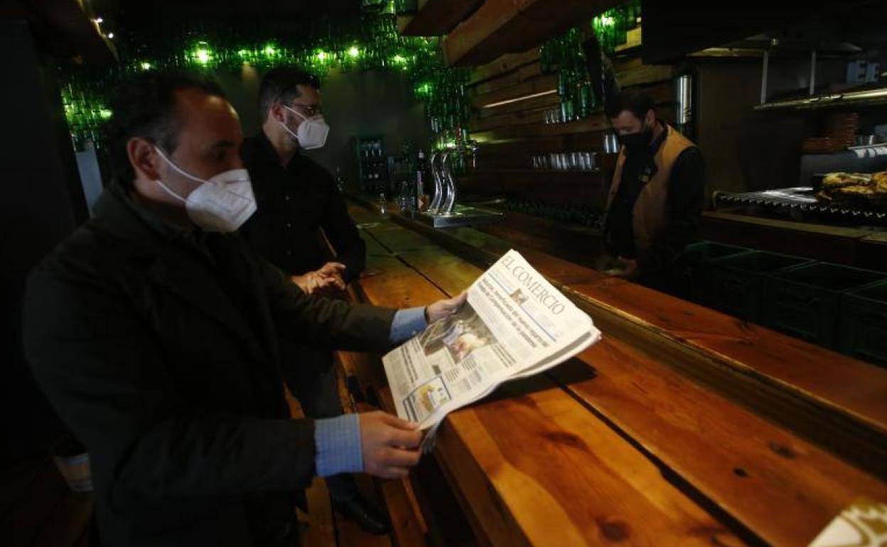 Dos personas, en la barra de un bar en Oviedo.