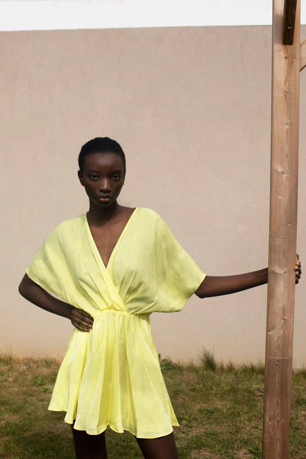 Vestido satinado en color amarillo con escote en pico cruzado de Zara, 29,95 euros.