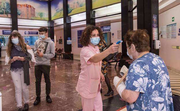 Una sanitaria toma la temperatura a los enfermos que entran al hospital de Basurto