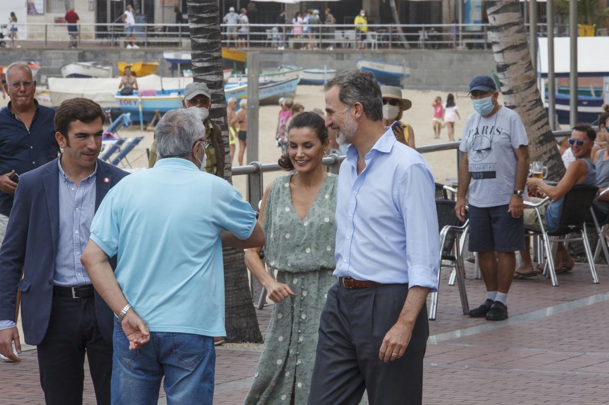 Doña Letizia y don Felipe, en el paseo de Las Canteras, saludando a un vecino con el codo.