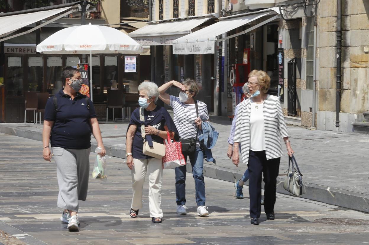 Paseantes, con mascarilla, por la plaza Mayor de Gijón. 