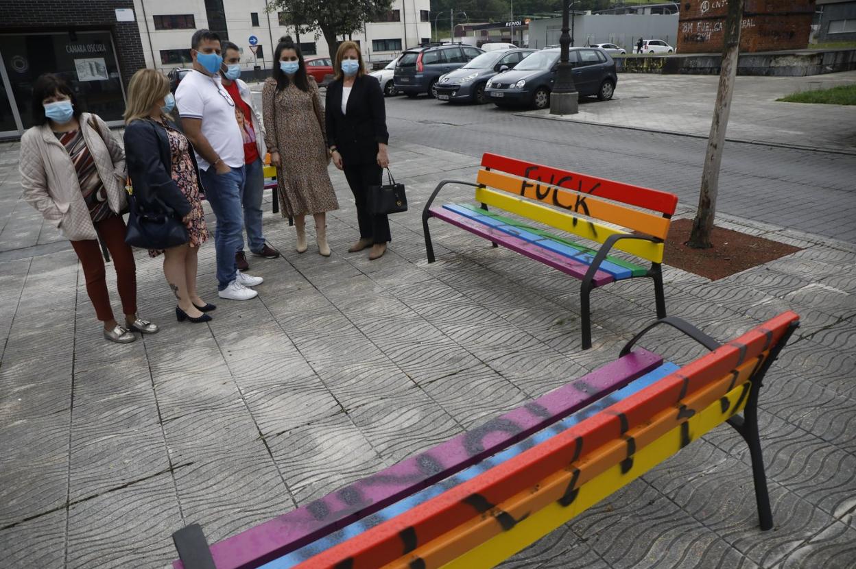 Parte de la Corporación de Langreo contempla los bancos arcoíris llenos de pintadas. 