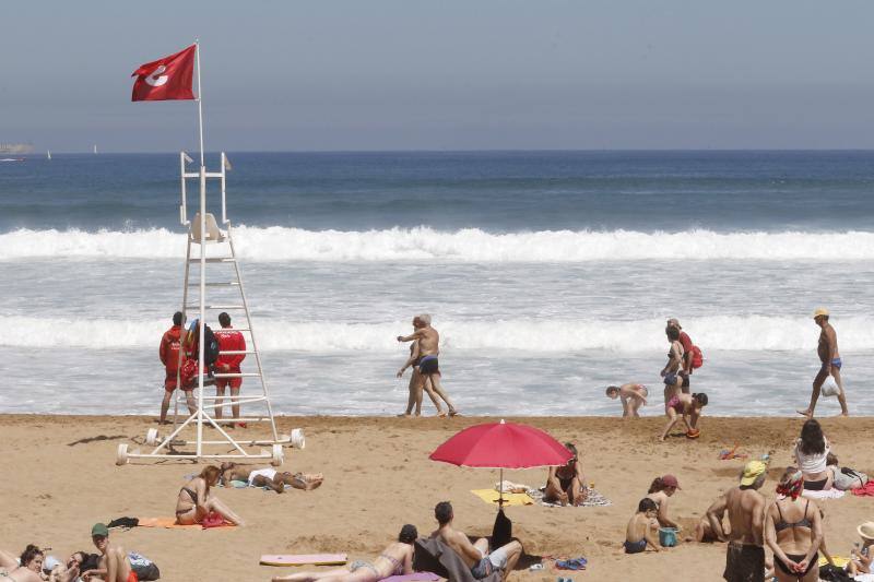 Asturianos y visitantes despiden junio con unas elevadas temperaturas que les ha llevado hasta playas y zonas de paseo con sombra.