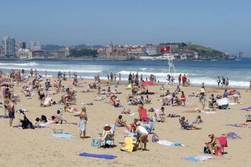 Asturianos y visitantes despiden junio con unas elevadas temperaturas que les ha llevado hasta playas y zonas de paseo con sombra.