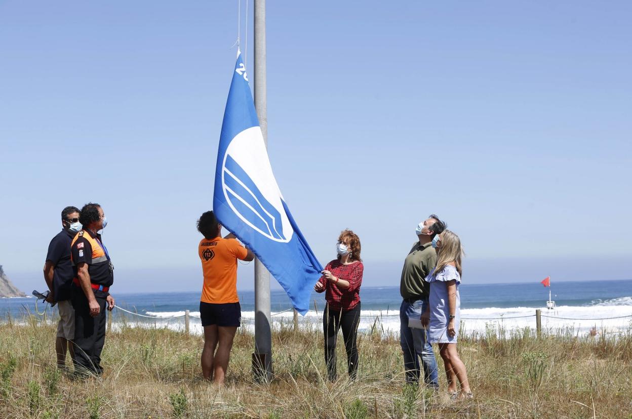Un socorrista iza la bandera azul en Rodiles. 