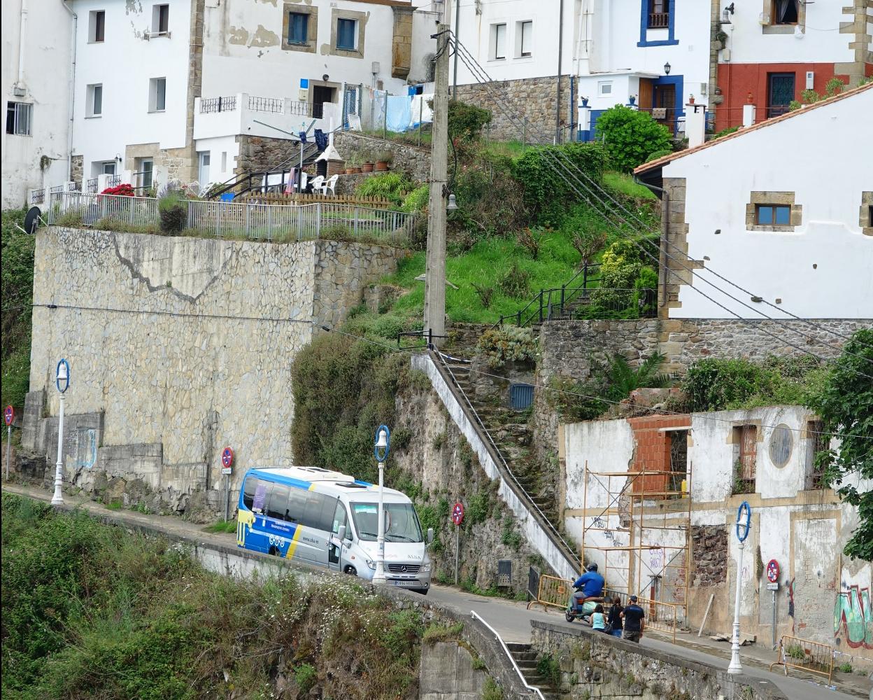 El autobús playero a su llegada al puerto, con Lastres de fondo. 