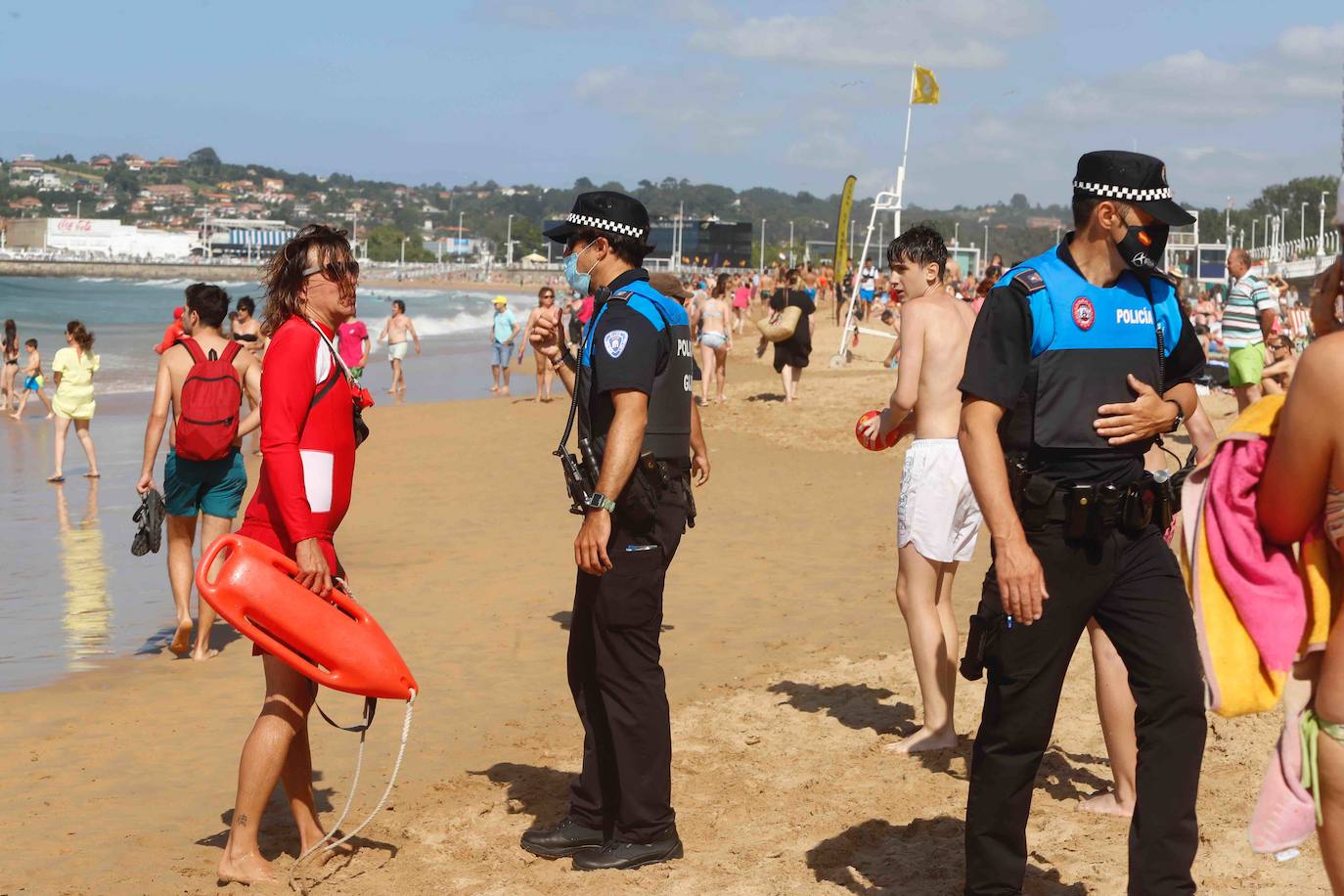 Gijoneses y visitantes han disfrutado del sol y del buen tiempo este martes en las playas. San Lorenzo se ha llenado de bañistas y la Policía Local de Gijón ha intervenido para garantizar el cumplimiento de las medidas de seguridad. 