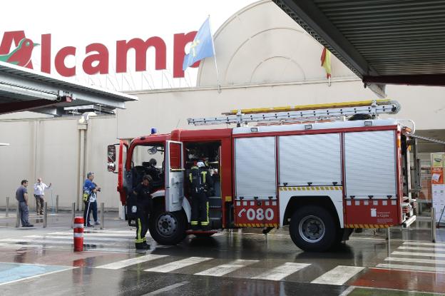 El camión de los bomberos, a la entrada del centro comercial. Empleados de Alcampo achican el agua en la entrada del centro comercial.Estado en el que quedó la cocina del restaurante tras el incendio.