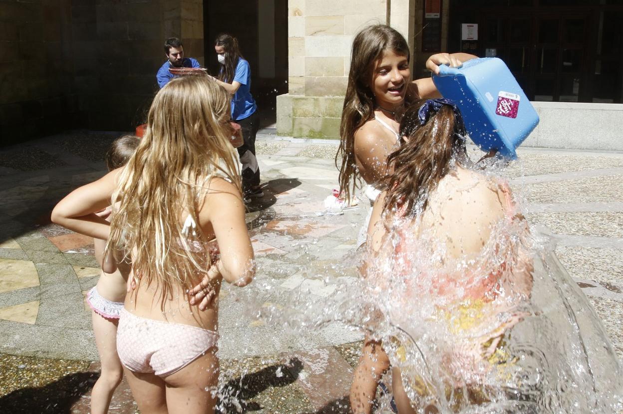 Cuatro niñas participan en una guerra de agua al cierre de una jornada del campus de verano. 