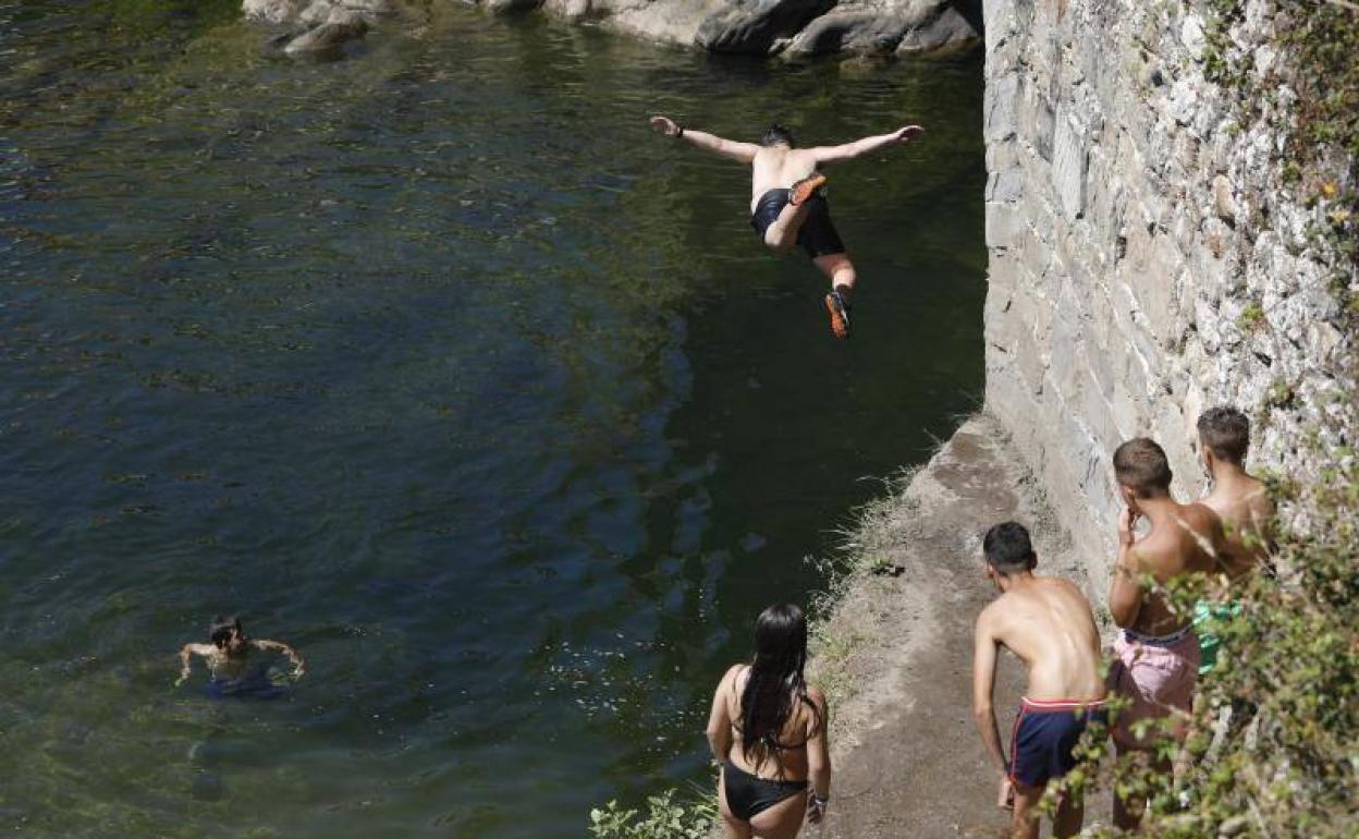 Un grupo de jóvenes se baña en el río Nalón, a la altura de puente de Arco en Laviana.