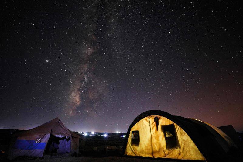 Parece que el mundo se detiene al observar el cielo estrellado de Idlib (Siria). Sin embargo, basta con bajar un poco la mirada para darse cuenta de la realidad: edificios destruidos por una guerra que comenzó hace más de nueve años y que parece no tener fin, un campamento para sirios desplazados, un parque de atracciones abandonado y combatientes a lo largo de la primera línea con las fuerzas gubernamentales. Así son las noches en la provincia de Idlib, controlada por los rebeldes sirios. 