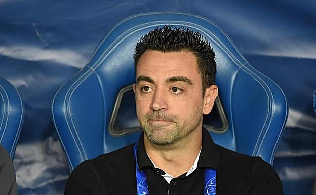 Xavi Hernández, sentado en el banquillo durante un partido. 