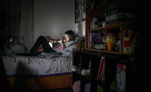 Una estudiante hace uso de las nuevas tecnologías en su habitación