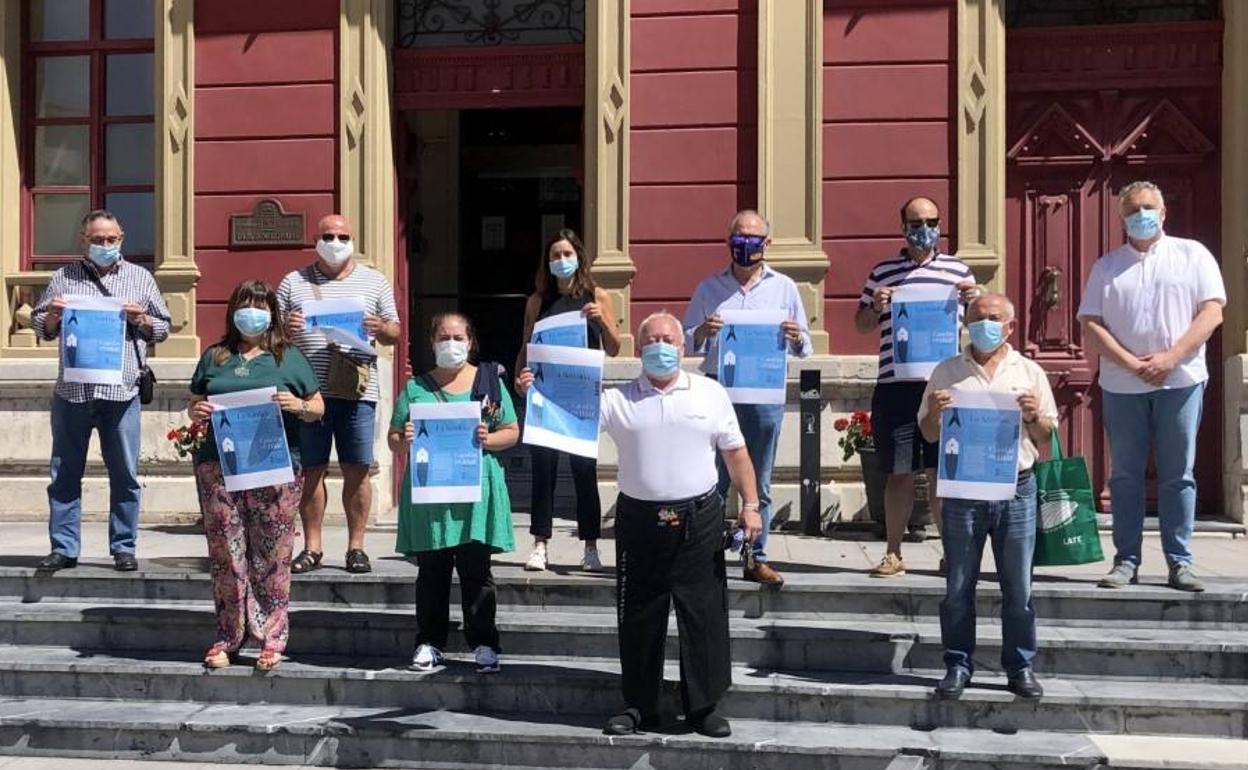 Representante del festival y responsables municipales posan con el cartel de la exposición. 