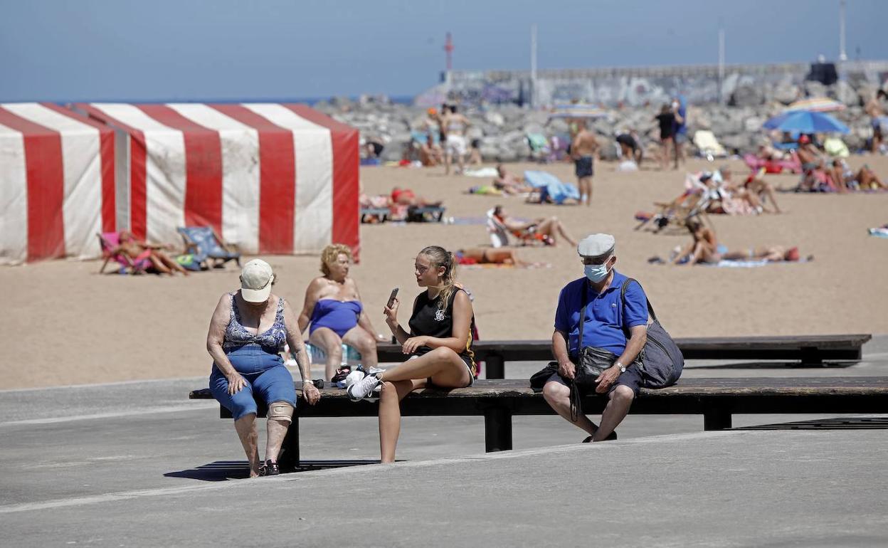 Los gijoneses se refrescan en la playa ante las altas temperaturas. 