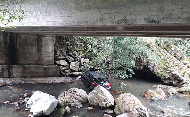 Imagen principal - Dos heridos tras caer con su coche al río en Proaza