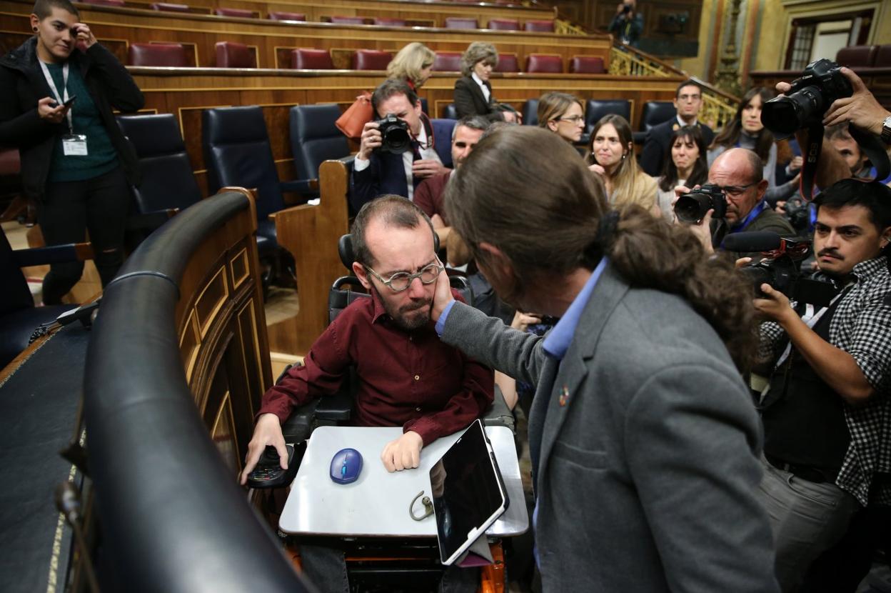 Pablo Iglesias saluda a un emocionado Pablo Echenique tras la investidura de Pedro Sánchez. 