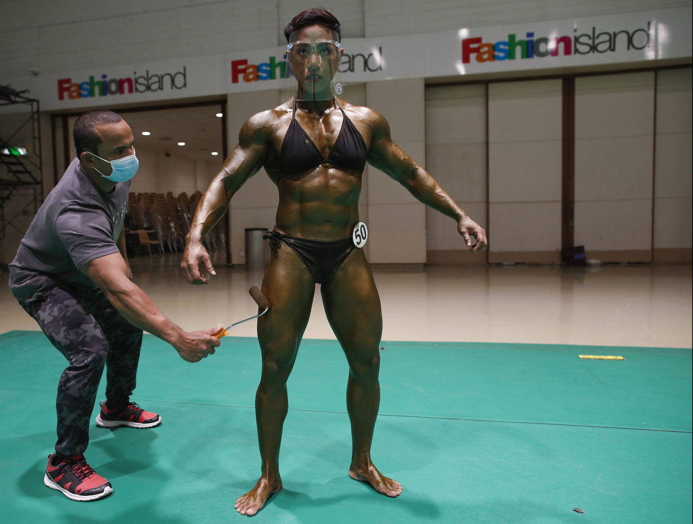 Protegidos con pantallas de plástico, decenas de concursantes compiten en el certamen de culturismo 'Mr. Tailandia' en Bangkok