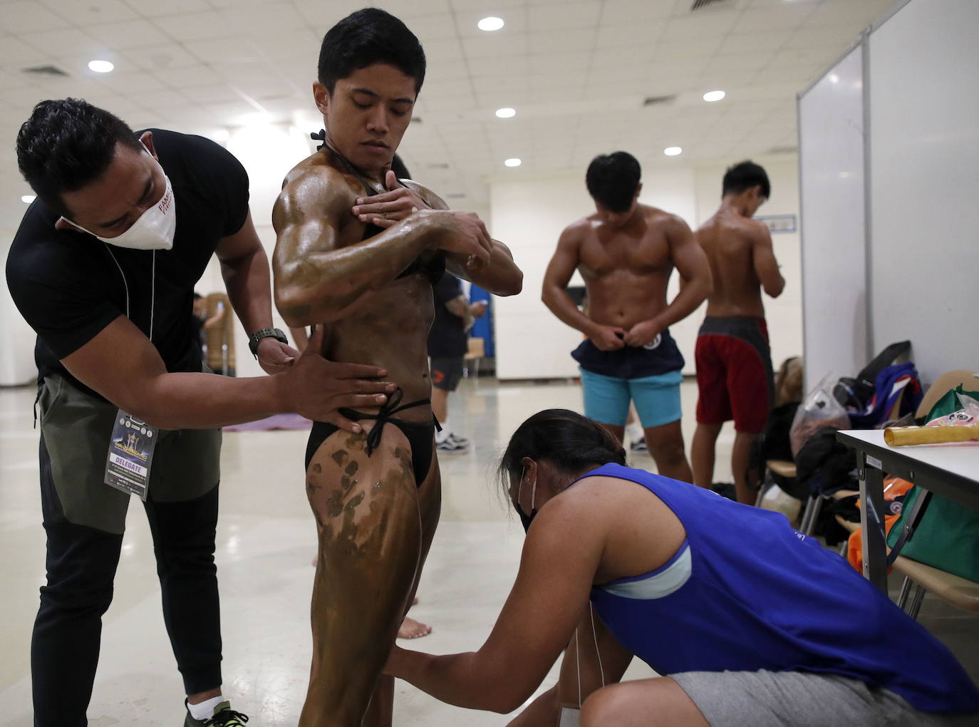 Protegidos con pantallas de plástico, decenas de concursantes compiten en el certamen de culturismo 'Mr. Tailandia' en Bangkok