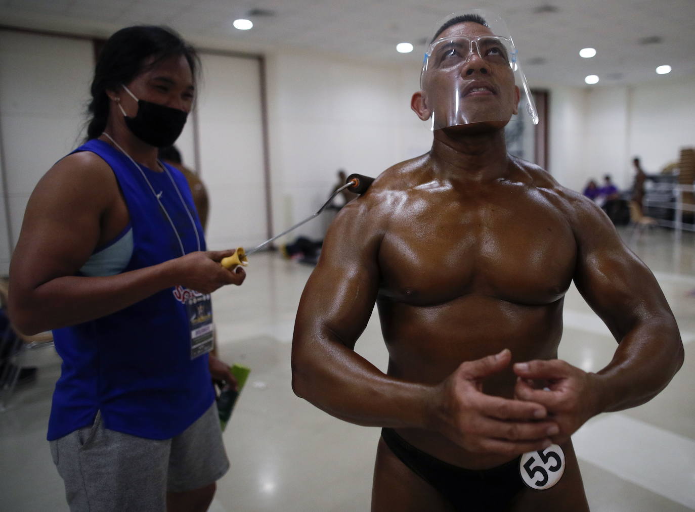 Protegidos con pantallas de plástico, decenas de concursantes compiten en el certamen de culturismo 'Mr. Tailandia' en Bangkok