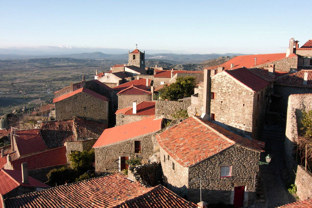 Monsanto (Portugal): Todo el pueblo de Monsanto está construido sobre rocas, con casas a menudo excavadas en la ladera de la montaña. Las calles que se retuercen entre las rocas están bordeadas de edificios de techos rojos que apenas han cambiado desde que se creó el pueblo en el siglo XII. La ciudad se enorgullece de su distinción como la ciudad más portuguesa de Portugal, un honor que se le otorgó en 1938.