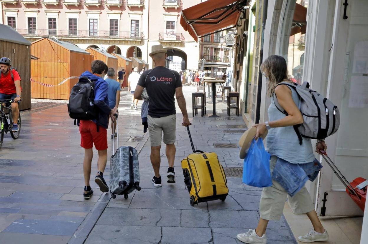 Un grupo de turistas abandona las instalaciones del Hotel Asturias, en plena plaza Mayor. 