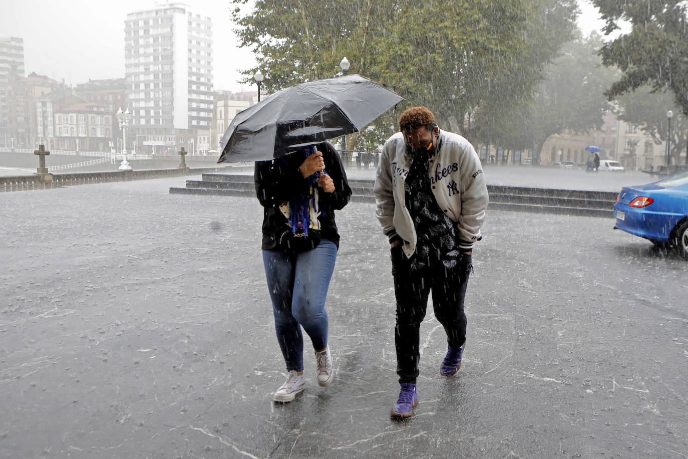 Una tromba de agua sorprendió a cuantos disfrutaban del domingo por Gijón