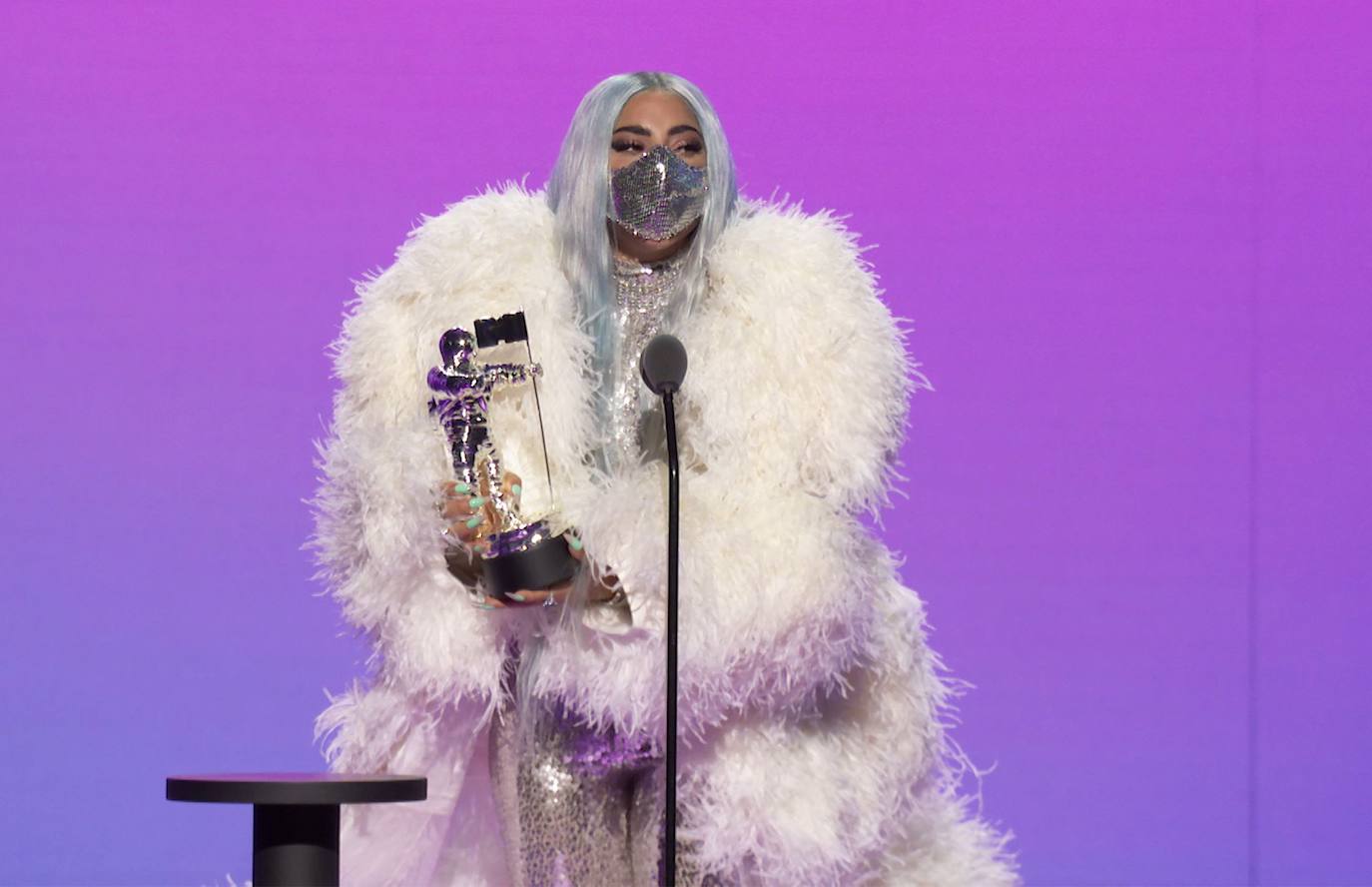 Lady Gaga fue la protagonista absoluta de la gala de los MTV Video Music Awards (VMA) 2020, no solo por los cinco galardones que se llevó, entre ellos el de artista del año, sino también por las sorprendentes mascarillas que lució en cada una de sus apariciones. La primera que llamó la atención fue una gran mascarilla rosas con alambres y malla metálica, pero después impactó con otra negra que tapaba prácticamente toda la cara y que en la zona frontal tenía una pequeña pantalla de luces que cambiaban de color. Más tarde, lució una de cuero decorada con largos cuernos en los laterales y pinchos metálicos. Esas fueron solo tres de las numerosas que usó para recoger sus cinco premios de la noche. Y es que, además de ser nombrada artista del año, recibió premios por 'Rain on Me', su proyecto con Ariana Grande: mejor colaboración, canción del año, y mejor fotografía. Además, se embolsó el primer premio 'Tricon' que se entrega en los VMAs, que reconoce el talento de un artista en tres o más disciplinas distintas. reconoce el talento de un artista en tres o más disciplinas distintas. 