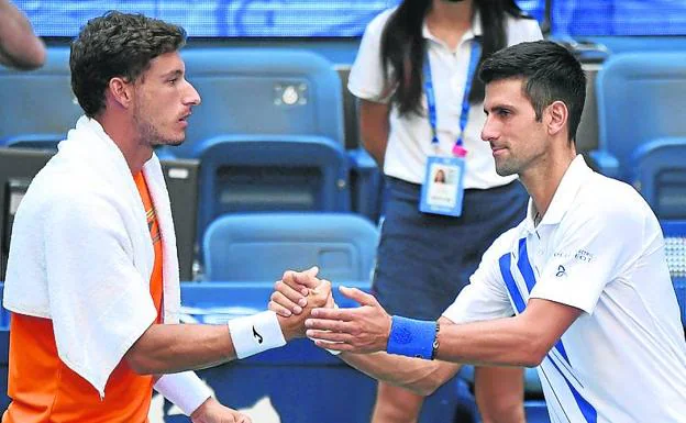 El serbio Novak Djokovic se despide del asturiano Pablo Carreño tras ser descalificado por golpear con una pelota a una juez de línea durante el partido de octavos de final. reuters