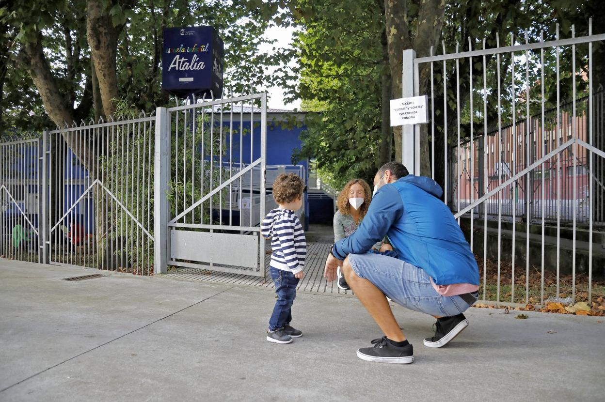David, de dos años, junto a su padre Javier, es recibido por la directora de la escuela Atalía, Encarna Somonte, en su primer día de vuelta al cole. 