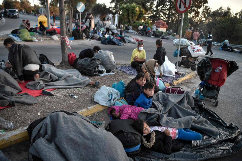 Miles de personas pasan la noche a la intemperie en los alrededores del devastado campo de refugiados de Moria (Lesbos), el más grande de Grecia, a la espera de ser trasladados. Las carreteras que rodean el campo, en el que malvivían 13.000 personas, están repletas de familias que con lo poco que les ha quedado se han instalado en la calzada o en alguna cercana al campo que no ha sido destruida por el incendio del martes por la noche; un incendio que comenzó simultáneamente en varios puntos del campo, poco después de que las autoridades comunicaran a 35 personas que habían dado positivo de covid-19 y que debían ser aisladas. 