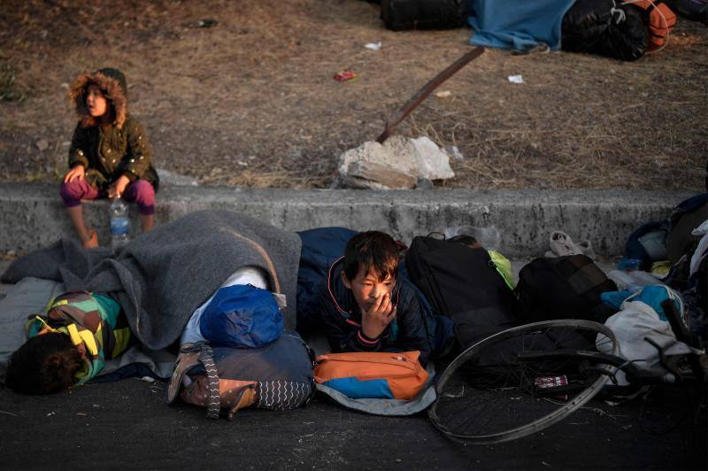 Miles de personas pasan la noche a la intemperie en los alrededores del devastado campo de refugiados de Moria (Lesbos), el más grande de Grecia, a la espera de ser trasladados. Las carreteras que rodean el campo, en el que malvivían 13.000 personas, están repletas de familias que con lo poco que les ha quedado se han instalado en la calzada o en alguna cercana al campo que no ha sido destruida por el incendio del martes por la noche; un incendio que comenzó simultáneamente en varios puntos del campo, poco después de que las autoridades comunicaran a 35 personas que habían dado positivo de covid-19 y que debían ser aisladas. 