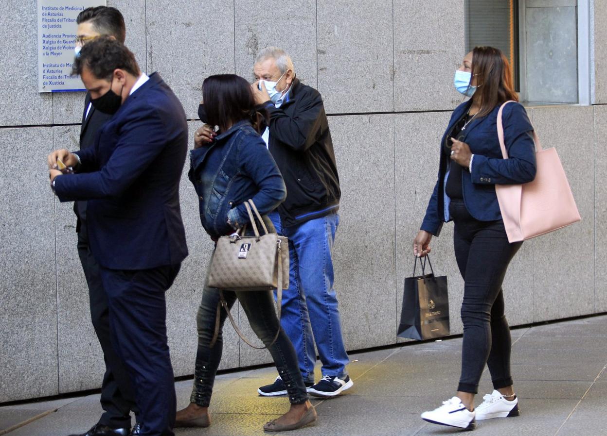 El acusado, entrando en la Audiencia con algunas de mujeres del club. 